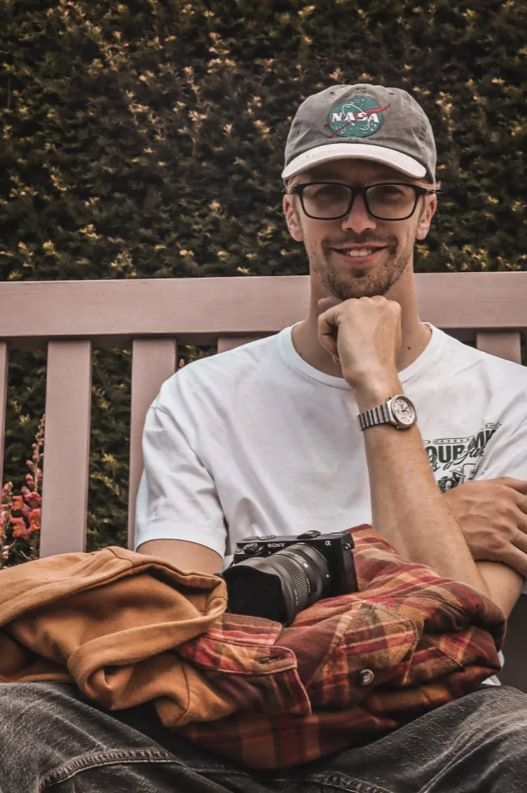 Sam seated with a camera.